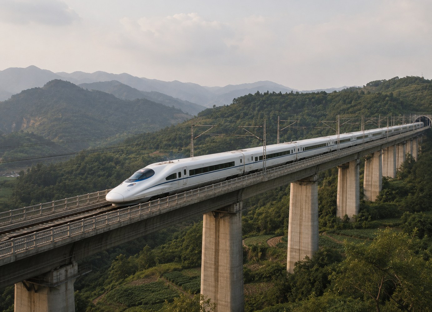 Chinesischer Hochgeschwindigkeitszug auf einem Viadukt in grüner Berglandschaft